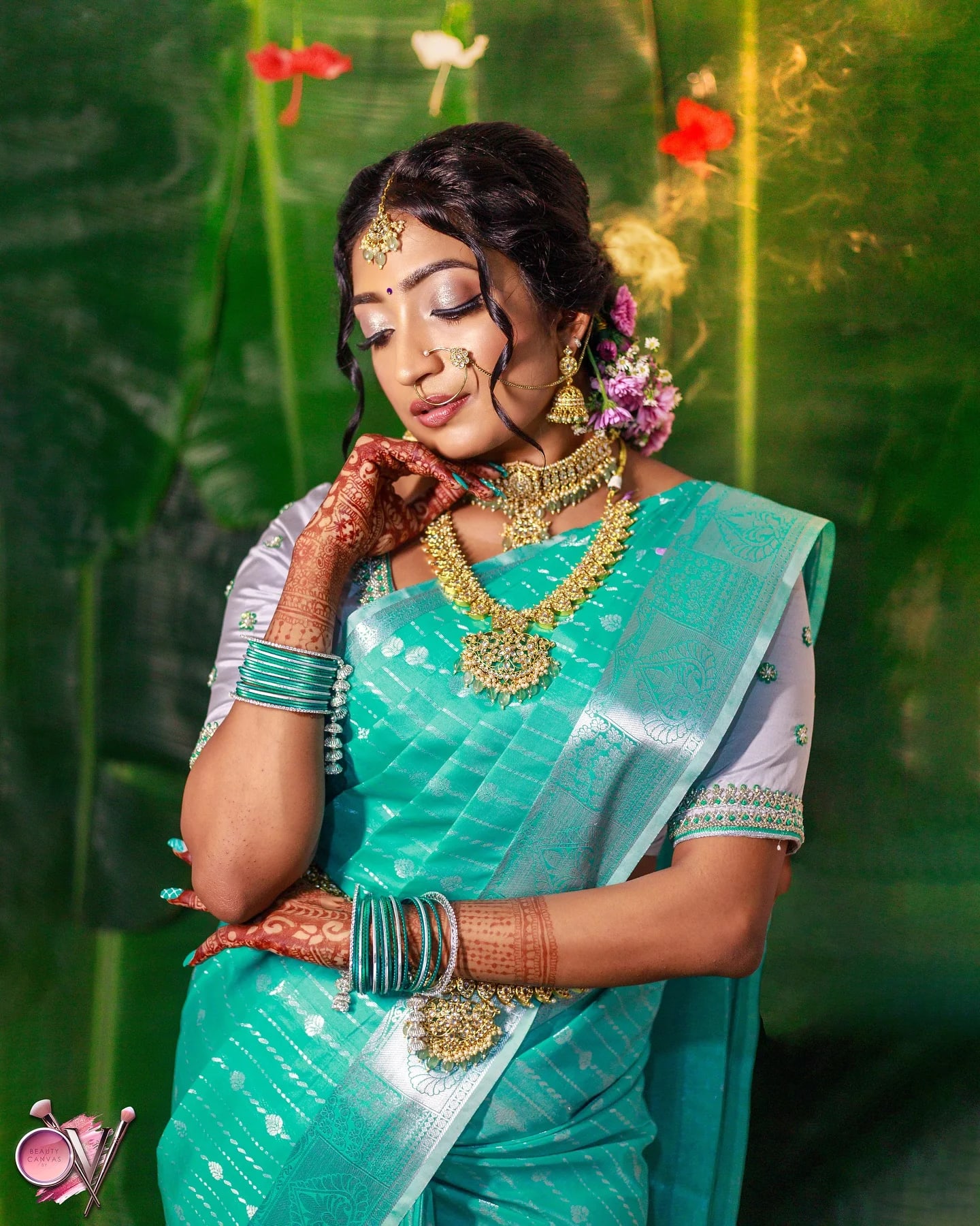 Teal Kanjivaram drape seen close, with the pallu over the shoulder and the woven border in view.