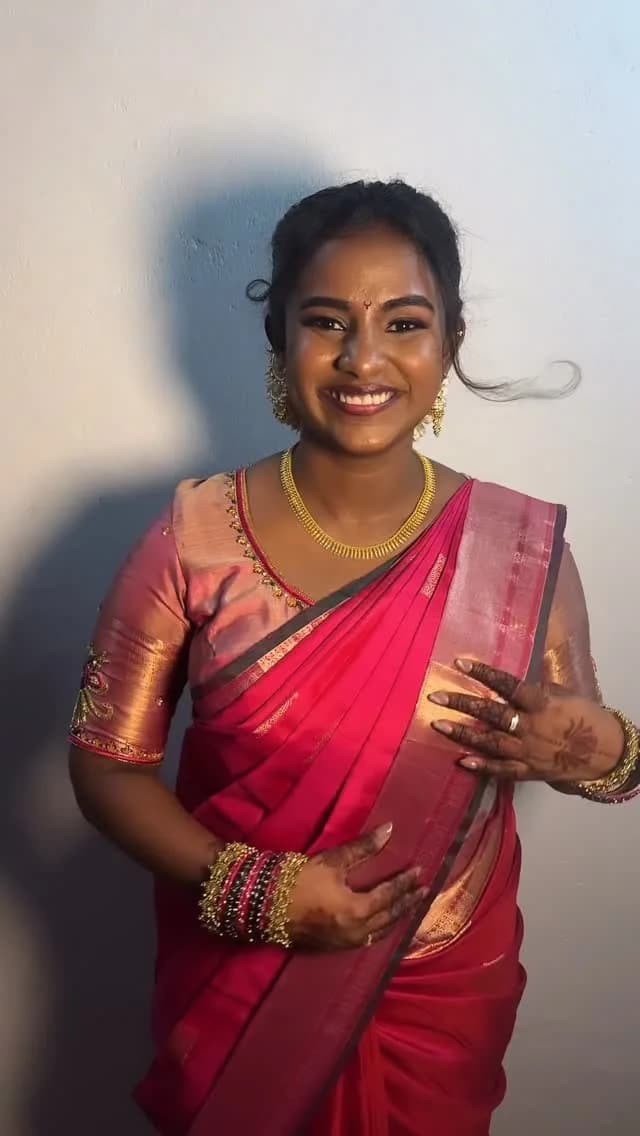 Wedding guest look in a pink and gold silk saree with gold jewellery.