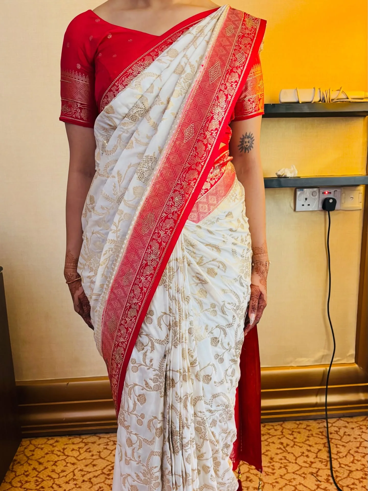Red and white Banarasi saree drape showing the pleats and pallu.