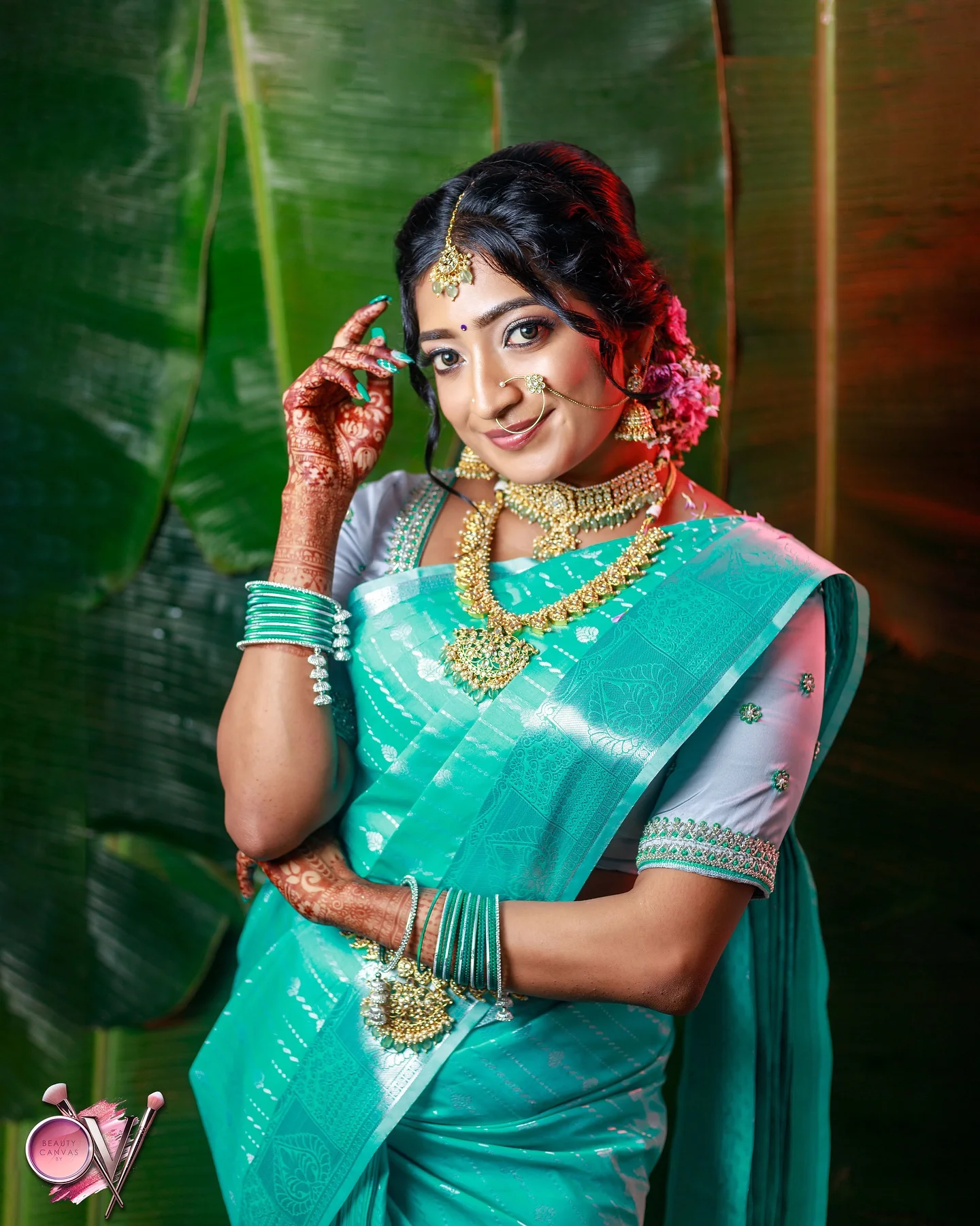 Teal Kanjivaram saree with gold temple jewellery, photographed beside banana leaves.